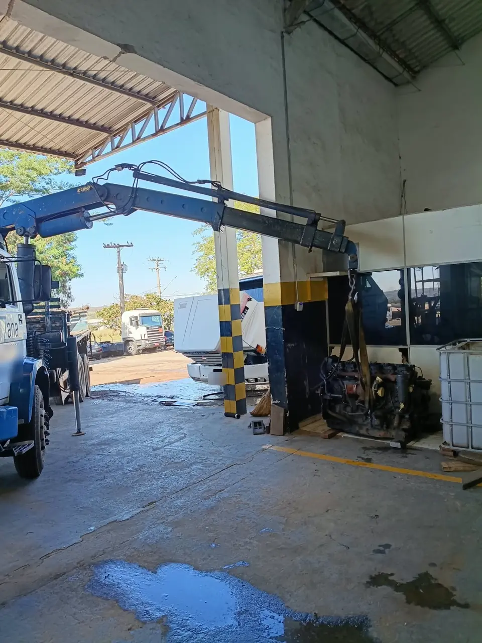Motor de caminhão suspenso pela lança do caminhão munck da Zana em oficina
