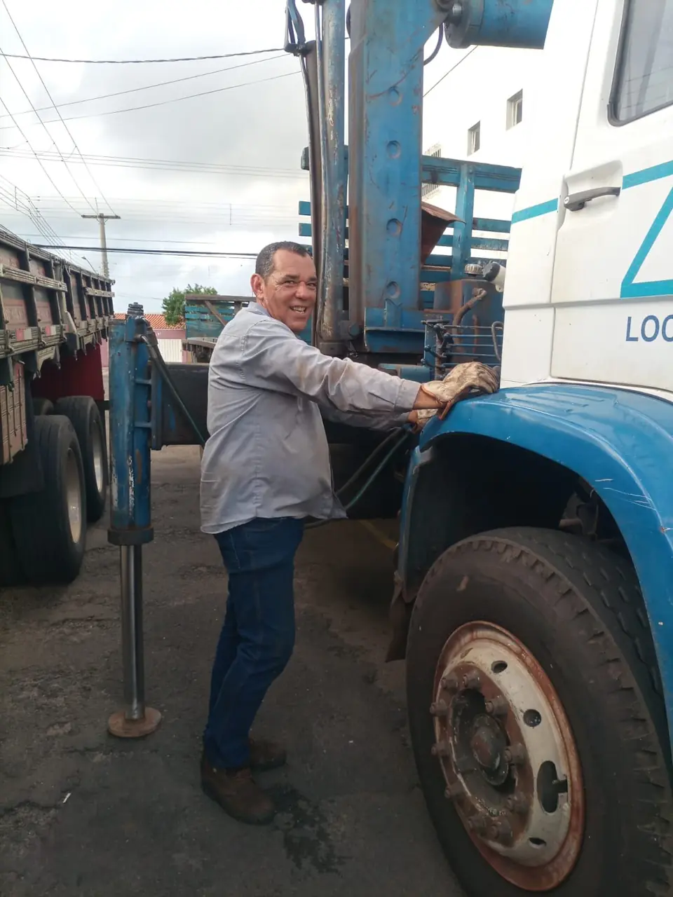 Operador do caminhão munck da Zana ao lado do equipamento, com luvas de trabalho